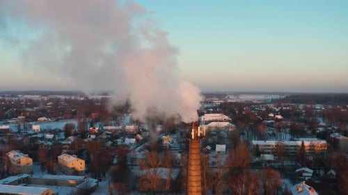 Sunset illuminated heat production chimney in city emit smoke in atmosphere