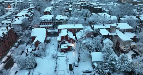 Rear backyard view of city homes covered in winter snow. Aerial truck shot at dusk, dawn. Beautiful