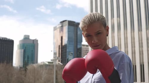 Businesswoman Throwing Punches Wearing Red Boxing Gloves Outdoors
