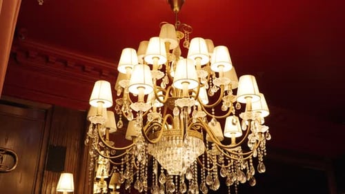 Crystal Chandelier Hanging Inside Antique Room With Red Ceiling. - closeup shot