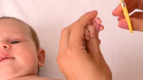 Mom Cuts Baby's Nails Selective Focus