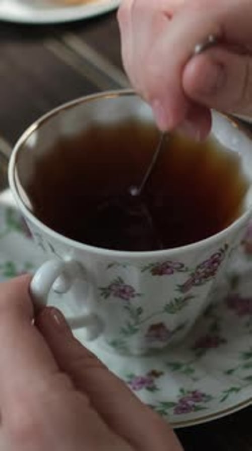 Vertical Video Hands Stirring Sugar in a Tea Cup
