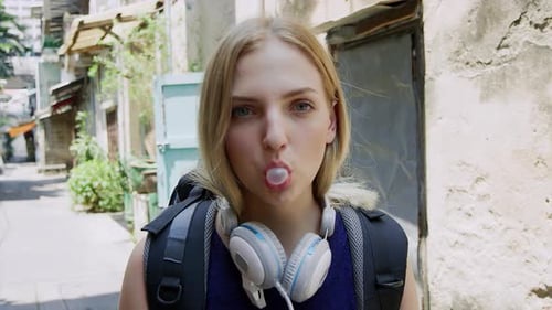 Portrait d'une belle touriste routarde soufflant du bonbon à la caméra