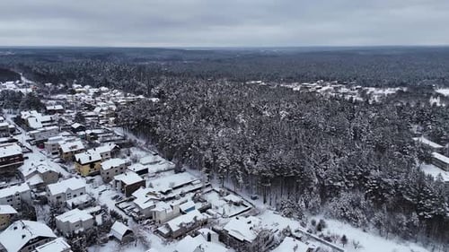 Forest in the backyard in Vilnius city neighborhood, Lithuania. Snowy winter from drone