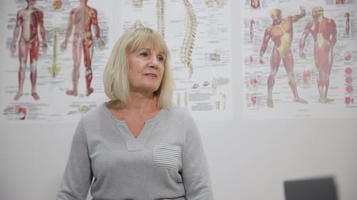 An Elderly Woman at an Orthopedic Doctor's Appointment with a Model of the Anatomy of the Human
