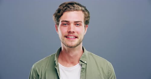 A man showing the peace sign against a grey background
