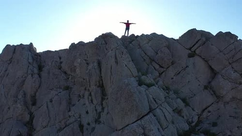 Man Standing On Top Of Cliffs With Aerial Shot