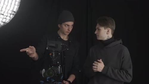 Male Videographer and Assistant Standing Near a Professional Camera and Reviewing the Image Men
