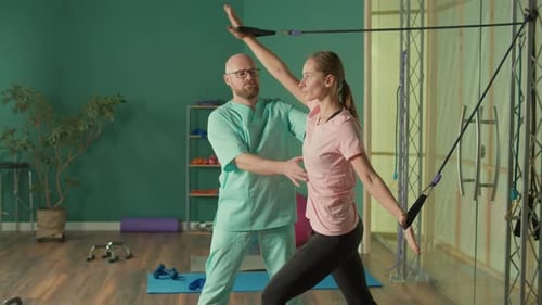 The Personal Trainer Helps the Athlete to Perform Exercises in the Gym