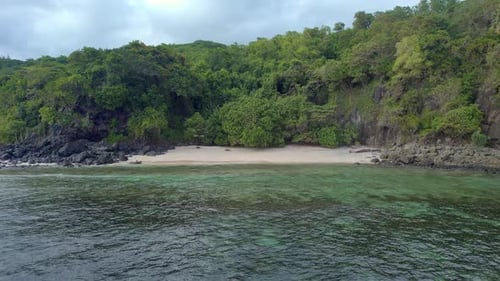 Vista aérea de la playa tropical con exuberantes acantilados verdes y aguas cristalinas