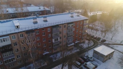 Multistory Apartment Building with Snowy Roof in City