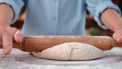 Housewife Rolling Out Dough for Bread or Pizza in Homemade Bakery Kitchen Closeup of Female Hands