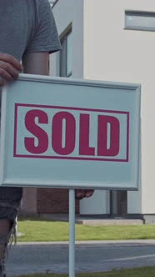 A Real Estate Sold Sign Displayed in Front of a Beautiful House for Potential Buyers