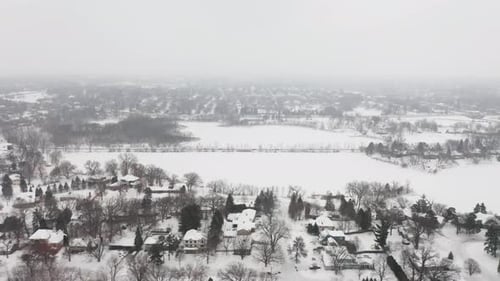 Aerial, snow covered houses in rural suburb neighborhood during winter