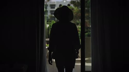 A Slender Young Woman Dressed in Summer Attire Wearing a Hat and Sunglasses Steps Out of Her Room
