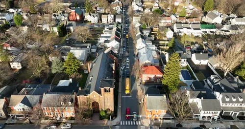 Traffic in small town USA. Yellow school, cars, vehicles on street in winter morning commute. Aerial