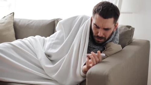 Concepto de infancia, salud y medicina: hombre enfermo con termómetro que mide la temperatura