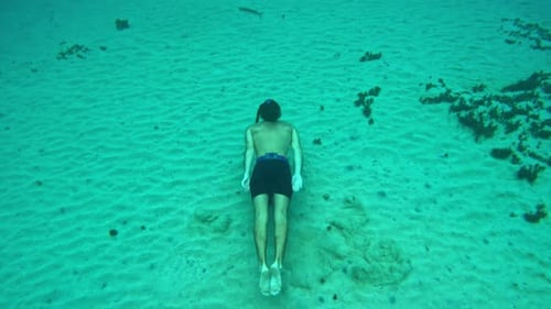 Man enjoys exhilarating underwater pursuit of free diving along the seabed