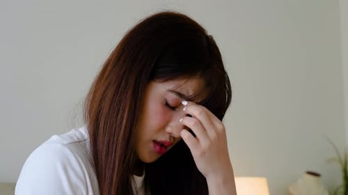Young asian female having depression sitting alone in bedroom corner. woman headache unhappy emotion