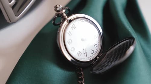 vintage pocket watch resting on green fabric
