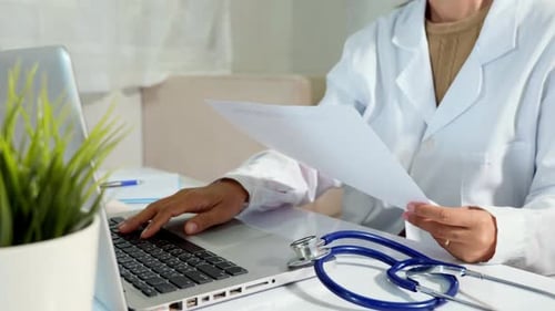 Doctora mujer escribiendo la información de la receta del paciente del papeleo médico en la computadora portátil