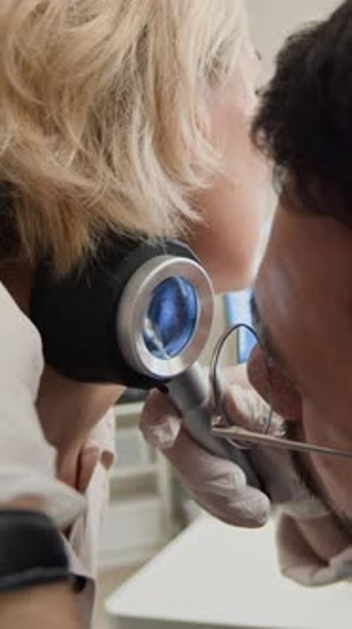 Vertical of Doctor Examining Suspicious Moles on Neck with Dermatoscope