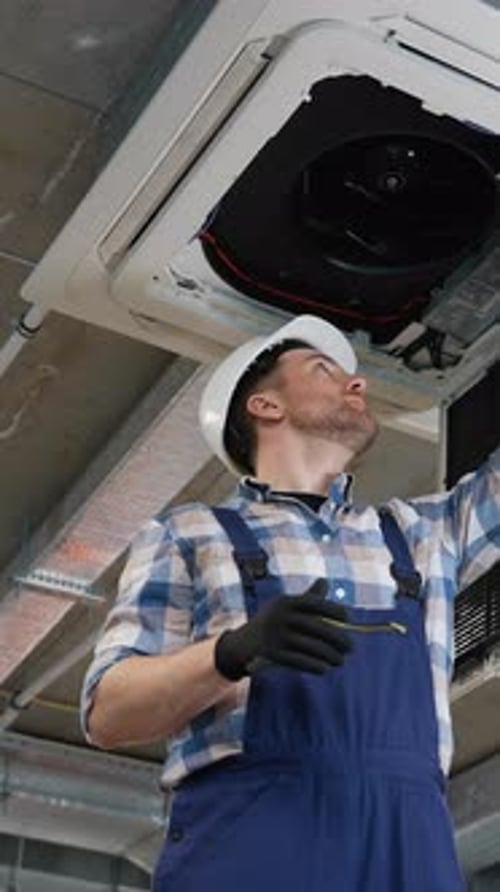 Technicien installant une unité de climatisation