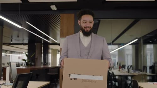 A New Worker Has Just Arrived at the Office Carrying Personal Belongings in a Box