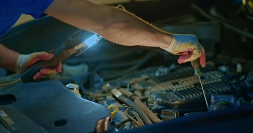 Auto Mechanic Working on Car Engine in Mechanics Garage