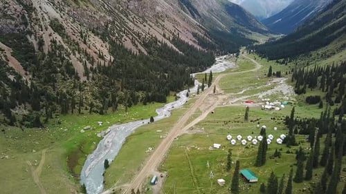 Aerial view of mountain recreation center with yurts and green meadow