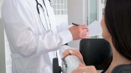An Orthopedic Doctor Examines a Woman in a Modern Clinic