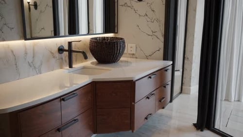 Discover an Elegant Bathroom with Stunning Marble Accents and a Modern Vanity Fixture