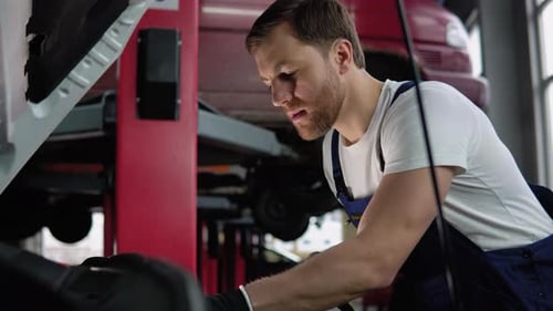 Automobile Mechanic Repairman Hands Repairing a Car Engine Automotive Workshop with a Wrench