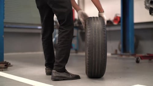 Mechanic man change a wheel tire and service maintenance the suspension of a vehicle