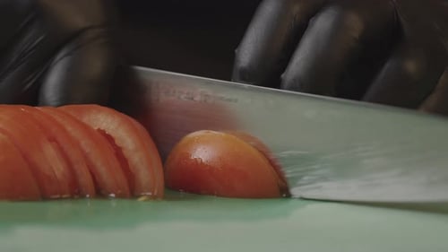 Closeup Slow Motion Video of a Chef Slicing a Tomato