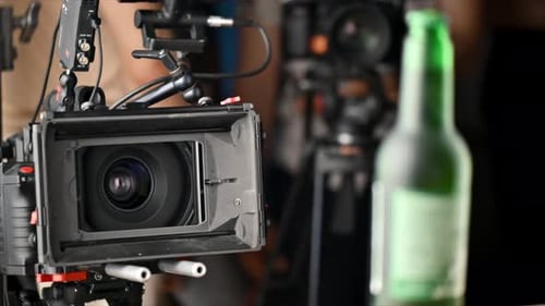 Professional camera shoots a bottle of beer on the set in a studio