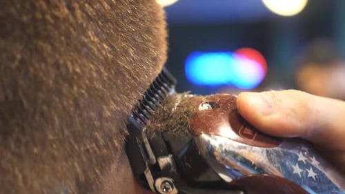 Close Up Hands of Hairstylist Cutting Hair of Guy with Electric Razor in Trendy Barbershop