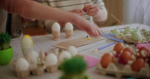 Mother and Daughter are Painting Easter Eggs for Easter Holidays