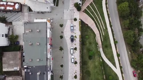 Aerial view of residential area, with garden, parked cars, next to a river
