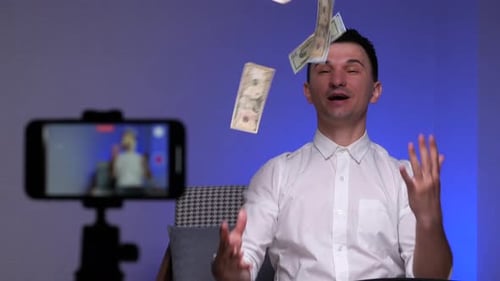 Blogger Man Shoots a Blog on the Phone About Finance and Scatters Money