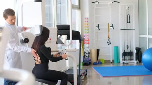 A Male Orthopedic Doctor Examines a Female Patient Spine Rehabilitator