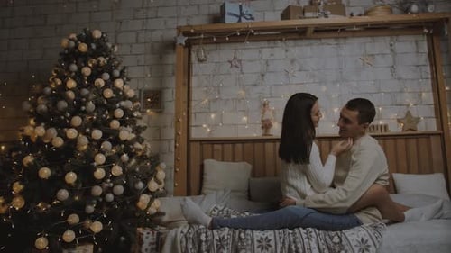 Young couple hugging and kissing at the bed