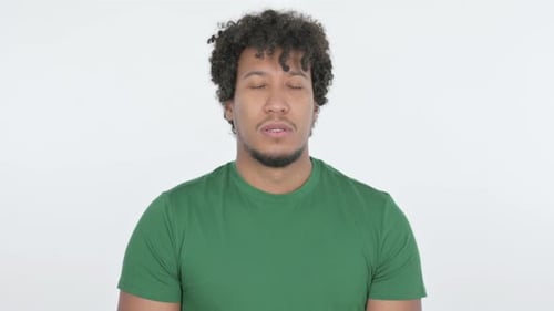 Triste hombre africano que se siente molesto sobre fondo blanco