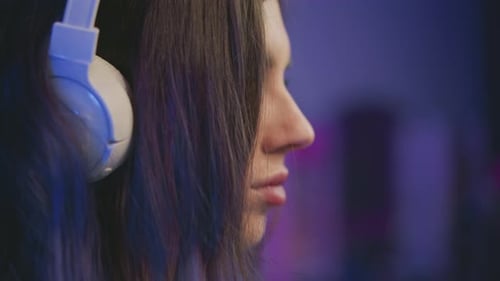 Close Up Side View of Woman Wearing White Headset Focusing Quietly