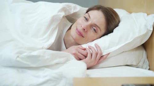 Peaceful serene young woman sleeping well in comfortable cozy white bed in the bedroom Close up shot