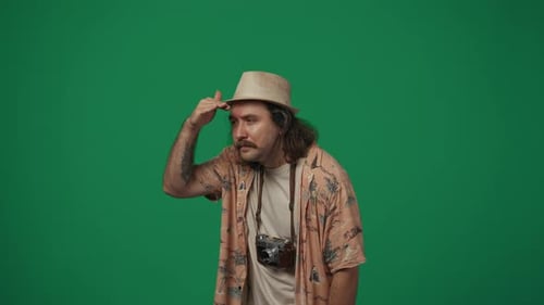 Hombre viajero con ropa casual y sombrero de paja con una vieja cámara de cine que busca a alguien que se da cuenta y