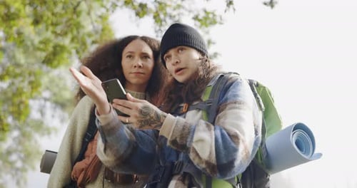 Friends, phone and lost people outdoor in nature on adventure, travel and hiking or camping trip