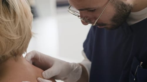 Male Doctor Examining Moles during Dermatology Consultation