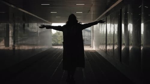 Silhouette of a Girl Dancing Against the Backdrop of an Underground Pedestrian Crossing