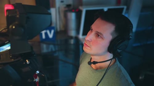 Cameraman Wearing Headset Operating Camera During Live Broadcast in Studio